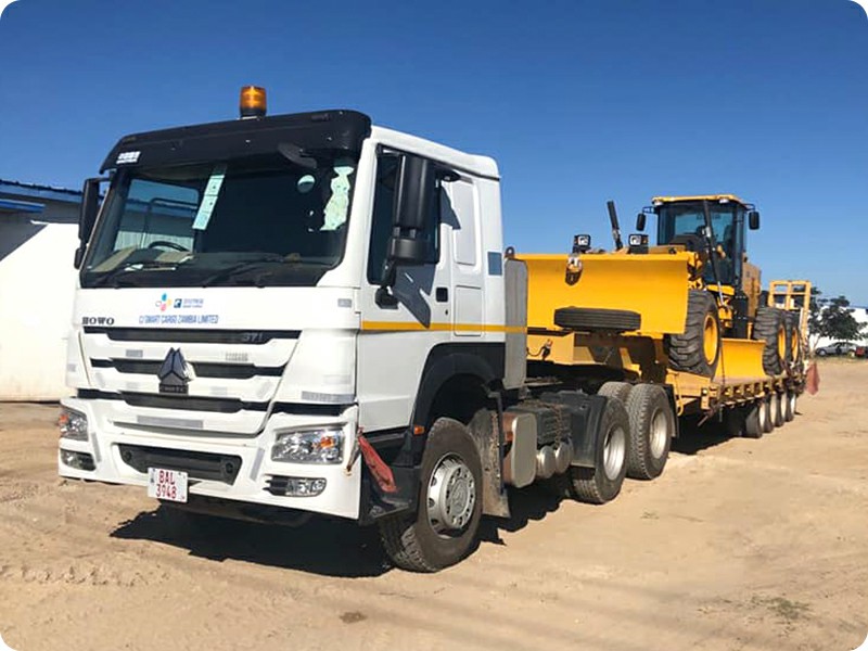 TRUCKMAN lowbed semi trailer transporting a motor grader